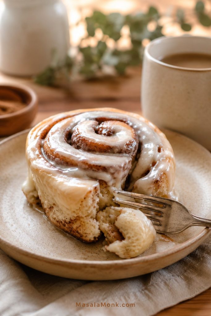 Single homemade cinnamon roll with cream cheese icing and soft cinnamon swirl