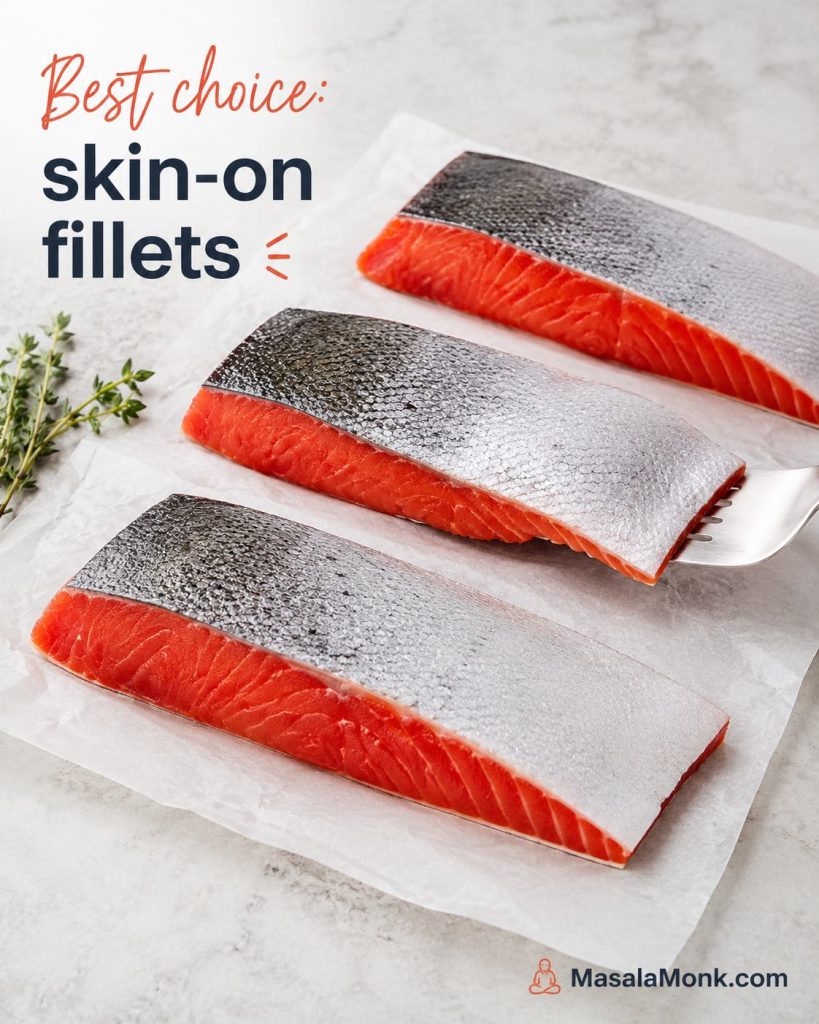 Three raw skin-on sockeye salmon fillets on parchment, with one fillet angled to show the skin.