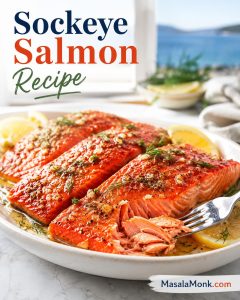 Baked sockeye salmon fillets with lemon wedges, herbs, and a fork lifting a moist flake.