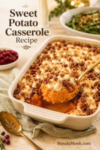 Sweet potato casserole in a cream baking dish with toasted marshmallows, pecan streusel, and a spoon lifting a creamy orange scoop.