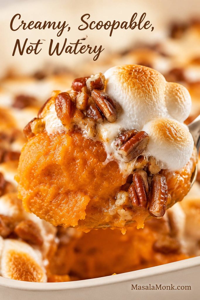 Close-up spoonful of sweet potato casserole showing creamy orange filling with pecan topping and toasted marshmallow pieces