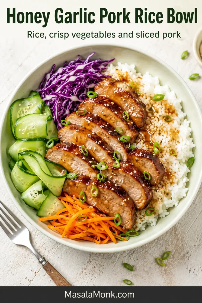Overhead rice bowl with sliced glazed pork, white rice, cucumber, purple cabbage, carrots, scallions and sesame seeds.