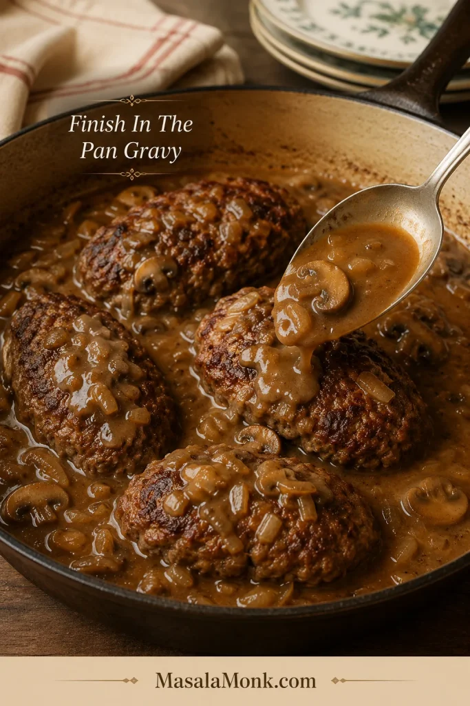 Browned Salisbury steak patties returned to mushroom gravy in a skillet.