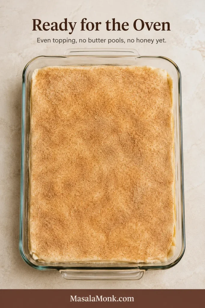 Unbaked Sopapilla Cheesecake in a rectangular glass baking dish with an even cinnamon-sugar coating and naturally imperfect dough edges.