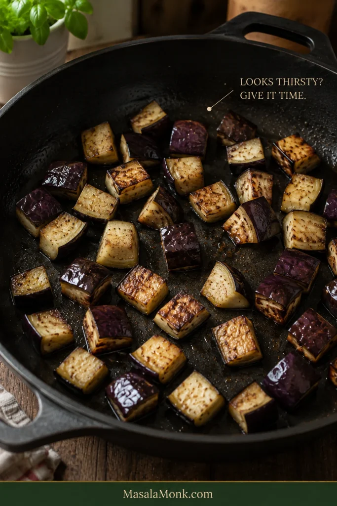 Eggplant chunks browning in a mostly dry-looking sauté pan with the words “Looks thirsty? Give it time.”