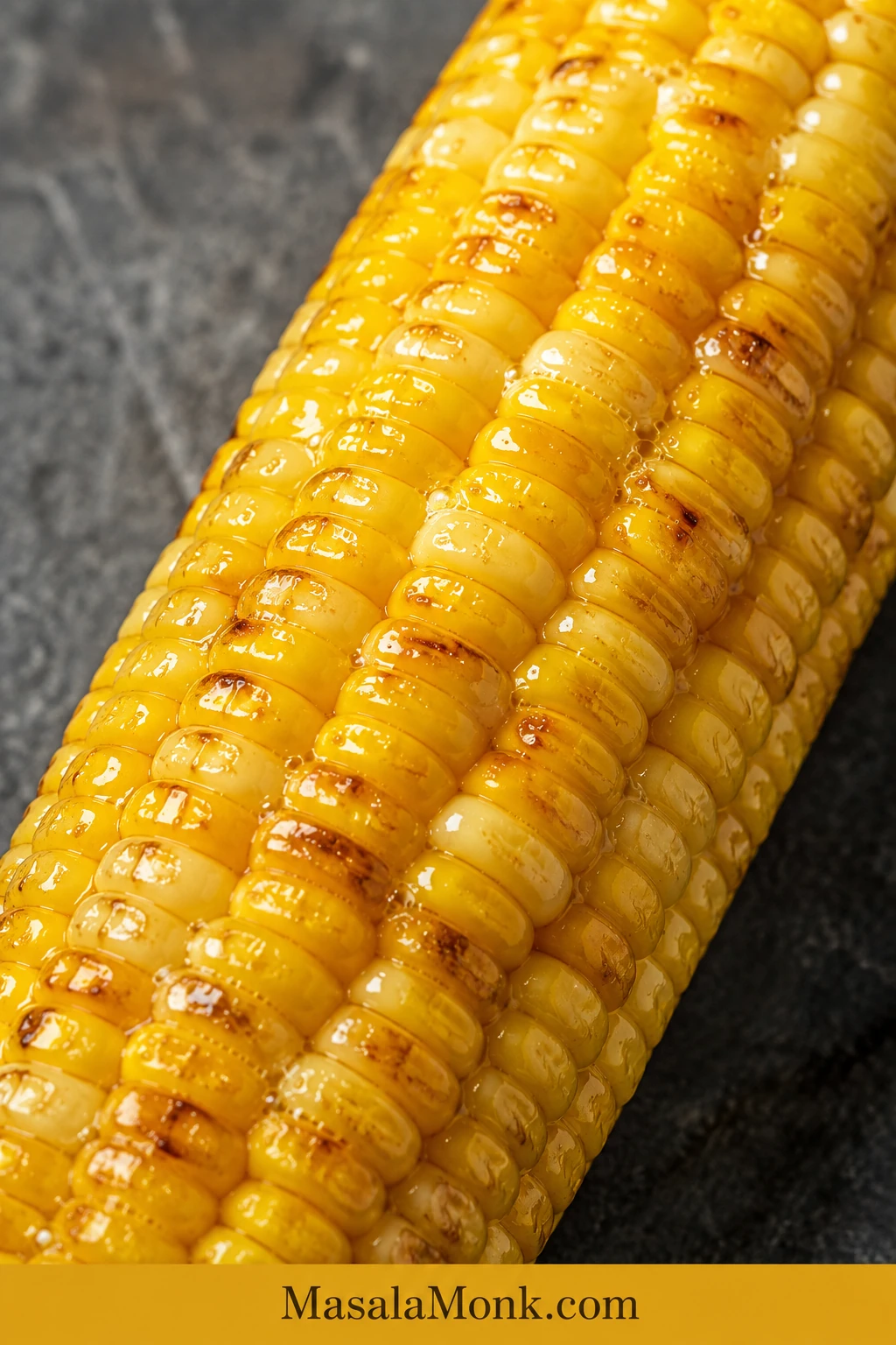 Close-up of plump air-fried corn kernels with melted butter between the rows, small beads of moisture and a few browned spots.
