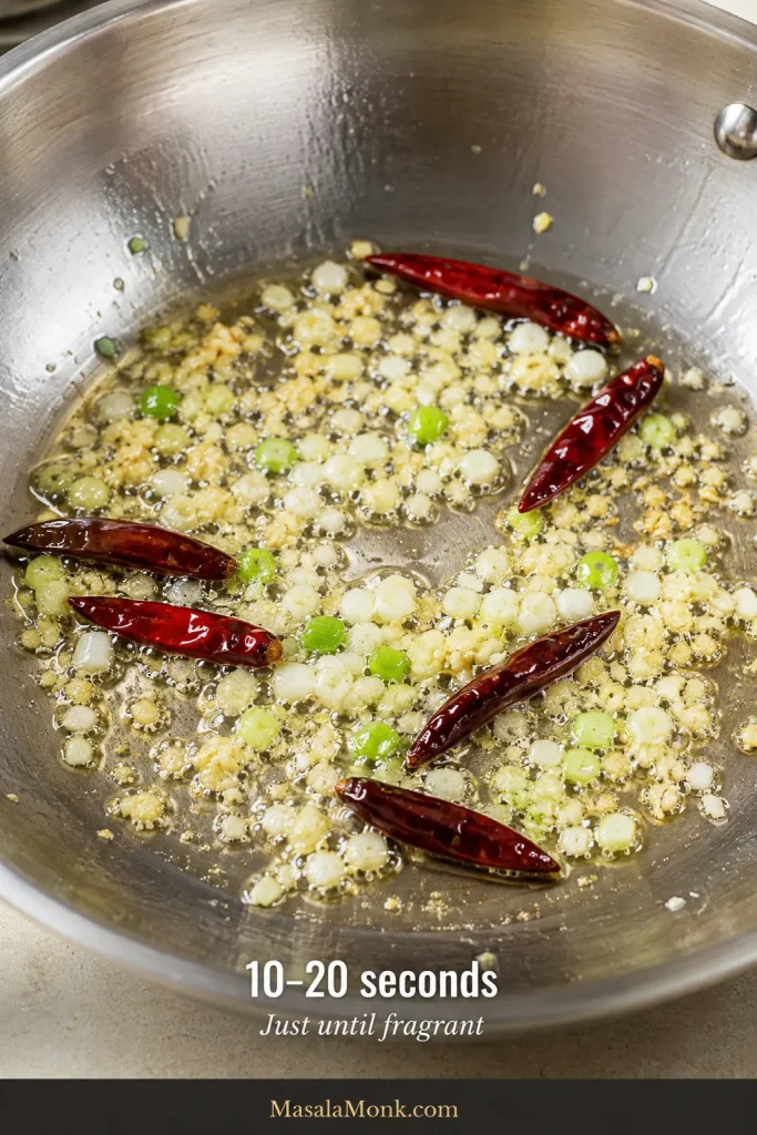 Dried red chillies, finely chopped ginger, garlic and scallion whites sizzling briefly in a thin layer of oil.