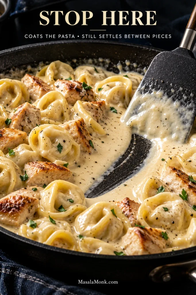 A spatula dragged through chicken tortellini Alfredo leaves a visible trail in the sauce; text reads “Stop Here” and “Coats the Pasta • Still Settles Between Pieces.”