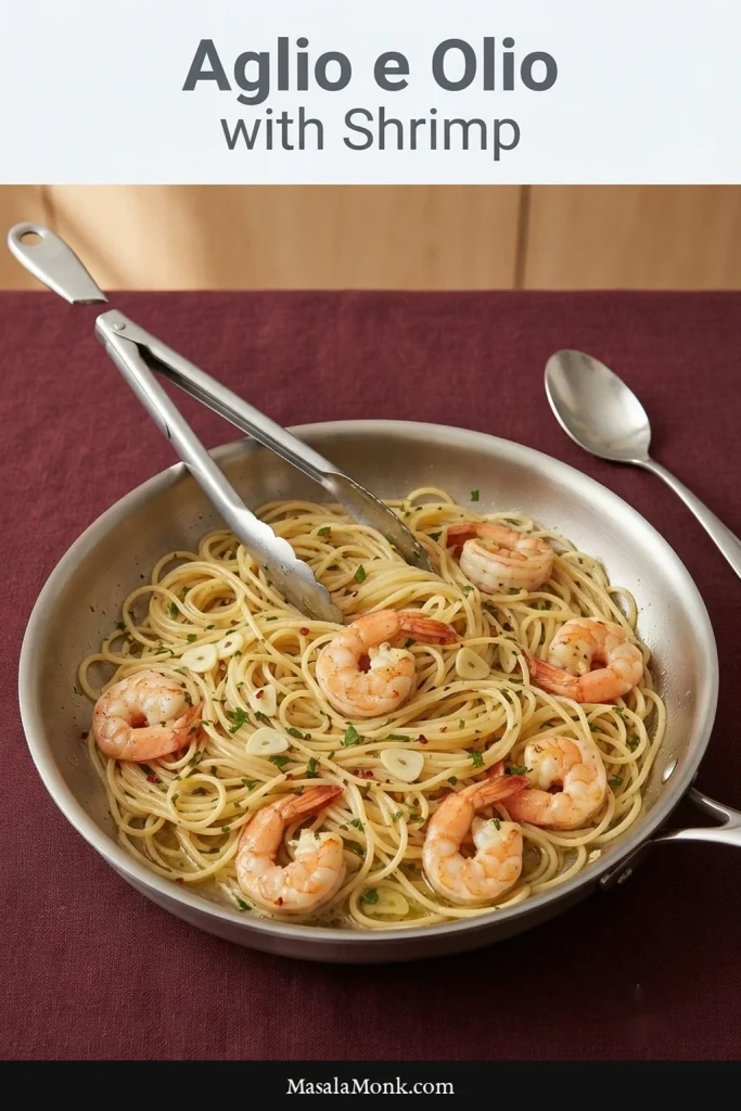 Plate of spaghetti aglio e olio with several seared shrimp, thin garlic slices, parsley, and small red chile pieces.
