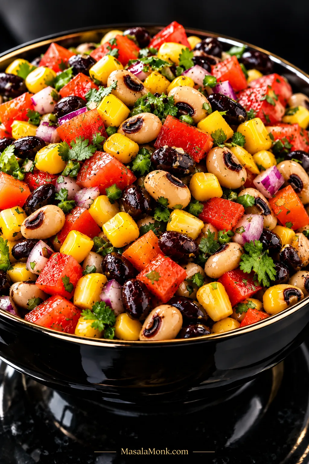 Close-up of Cowboy Caviar with black-eyed peas, black beans, corn, tomato, bell pepper, red onion and cilantro lightly coated in vinaigrette without pooled oil.
