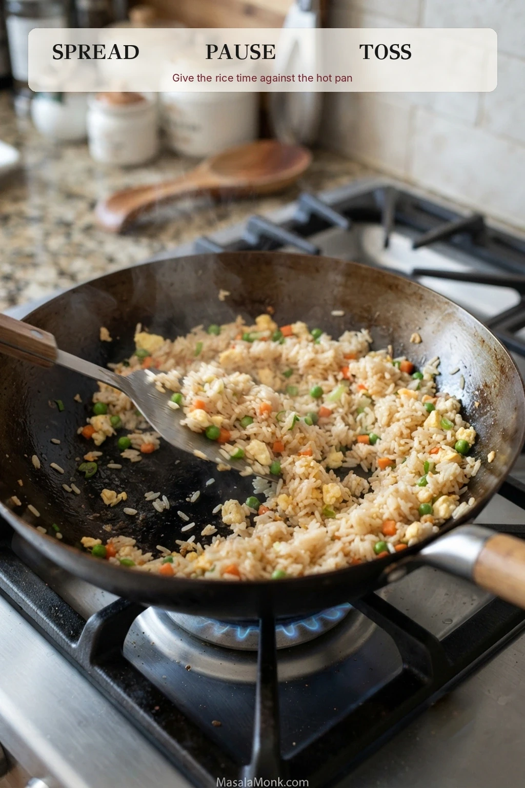Fried rice spread in a shallow layer across a hot wok with a spatula and the words spread, pause and toss above the pan.