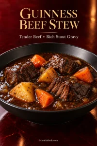 Bowl of Guinness beef stew with large braised beef chunks, yellow potatoes and carrots in dark glossy gravy.