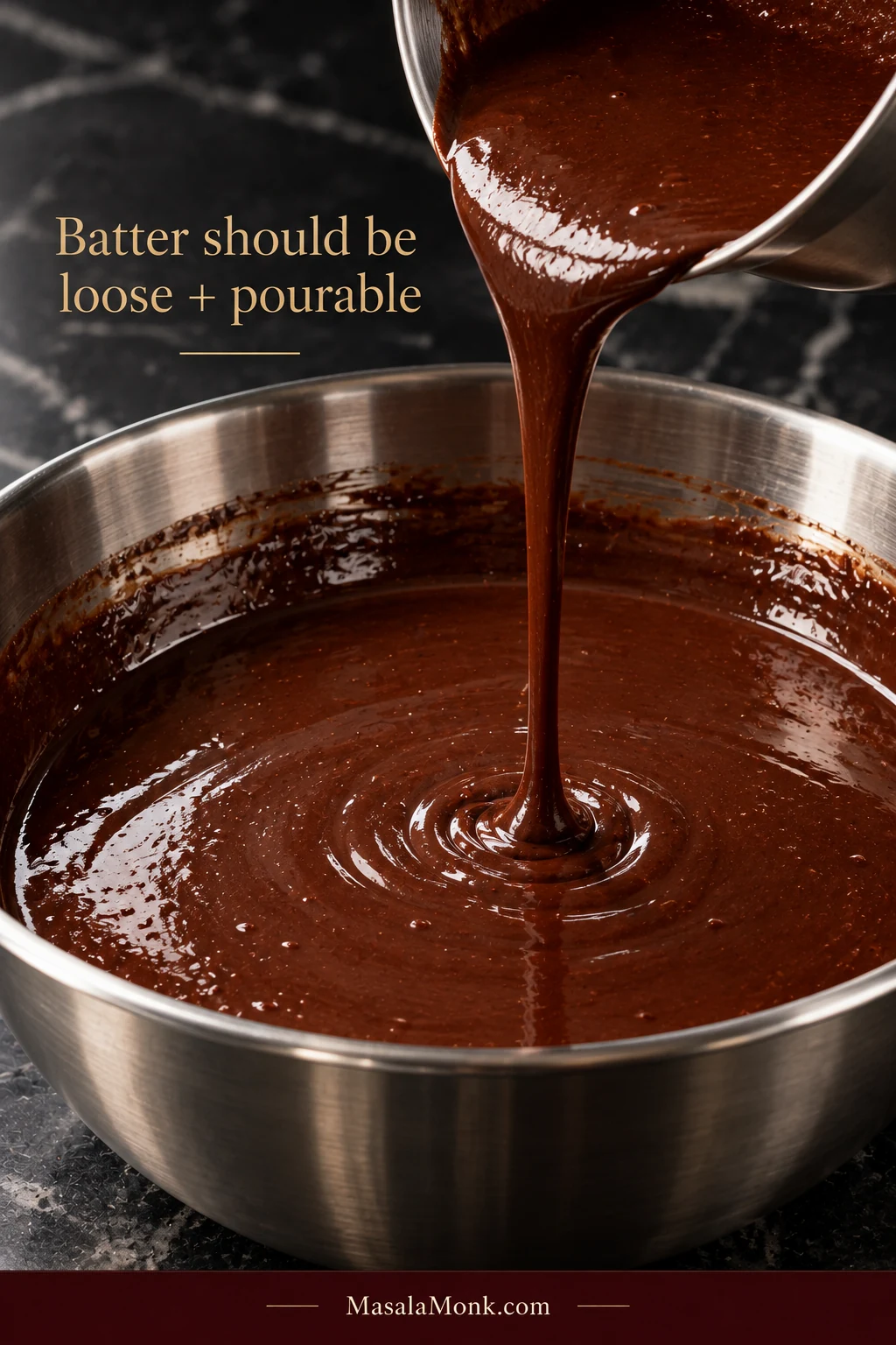 Thin dark chocolate cake batter pouring in a narrow stream into a stainless-steel bowl; overlay reads “Batter should be loose + pourable.”