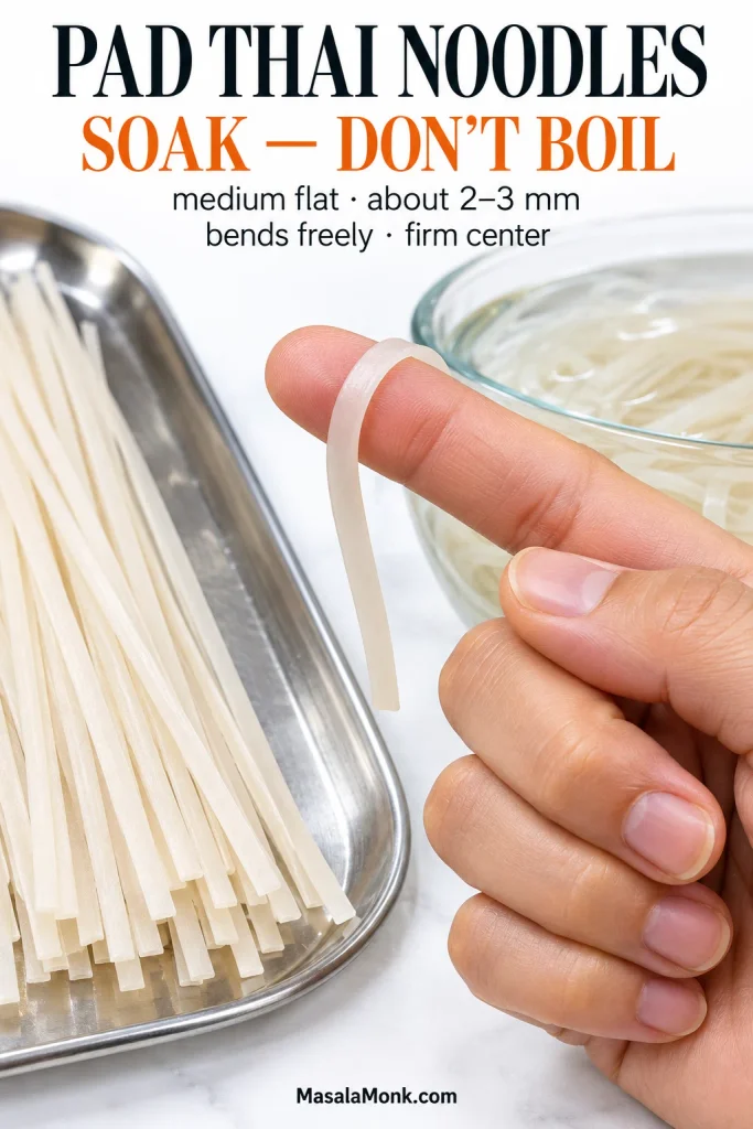 Hand bending a soaked flat rice noodle around a finger beside dry rice noodles and a bowl of soaking noodles, showing a flexible noodle that still holds its shape.