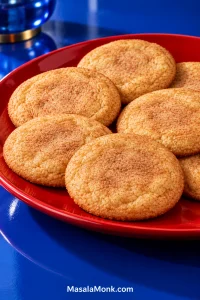 Soft, medium-thick cinnamon-sugar Snickerdoodle cookies arranged on a red plate, with gently settled centers and lightly cracked tops.