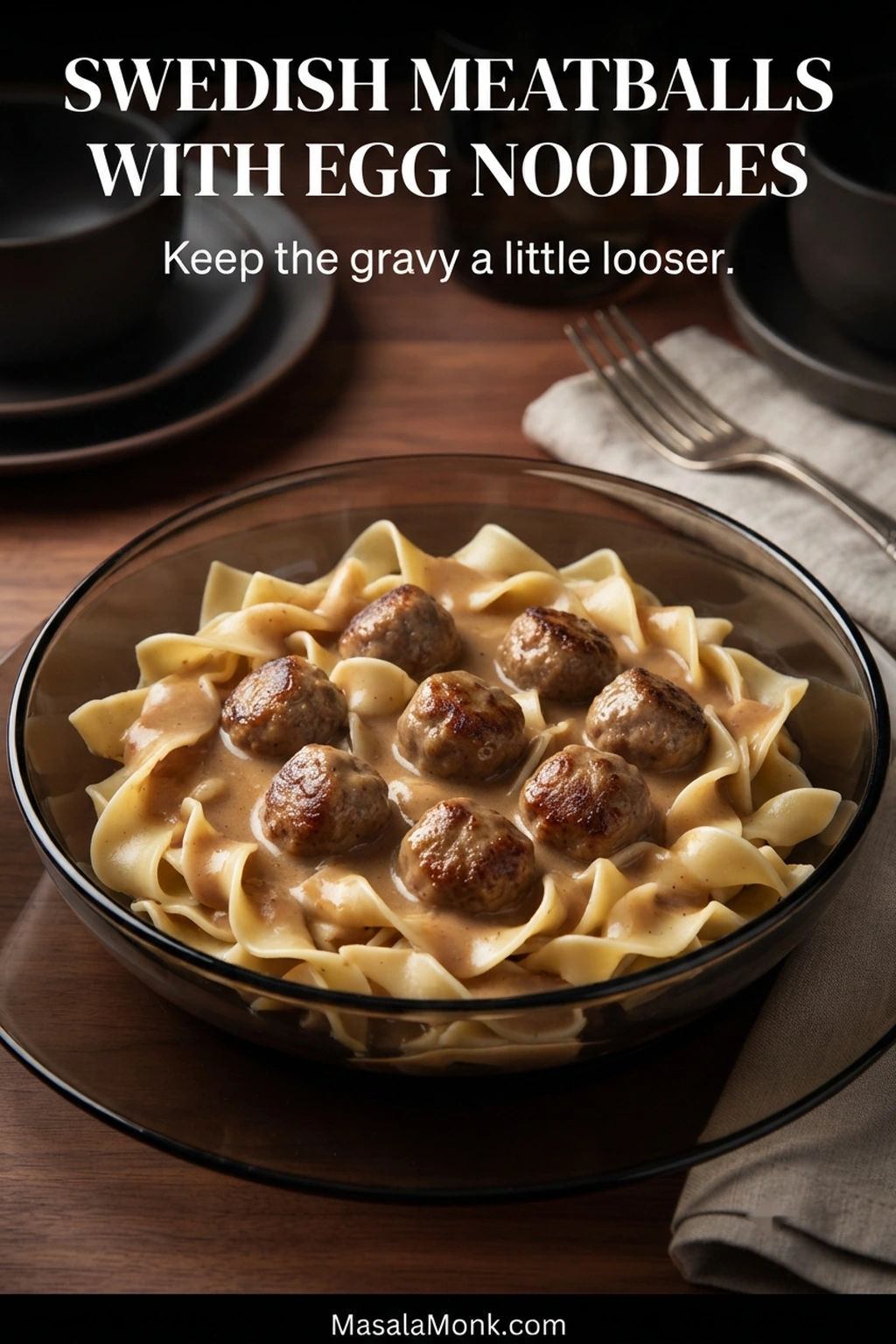 Swedish meatballs in creamy brown gravy served over broad egg noodles, with sauce flowing between the noodle folds.